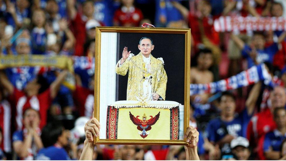 Man holding picture of King Bhumibol Adulyadej